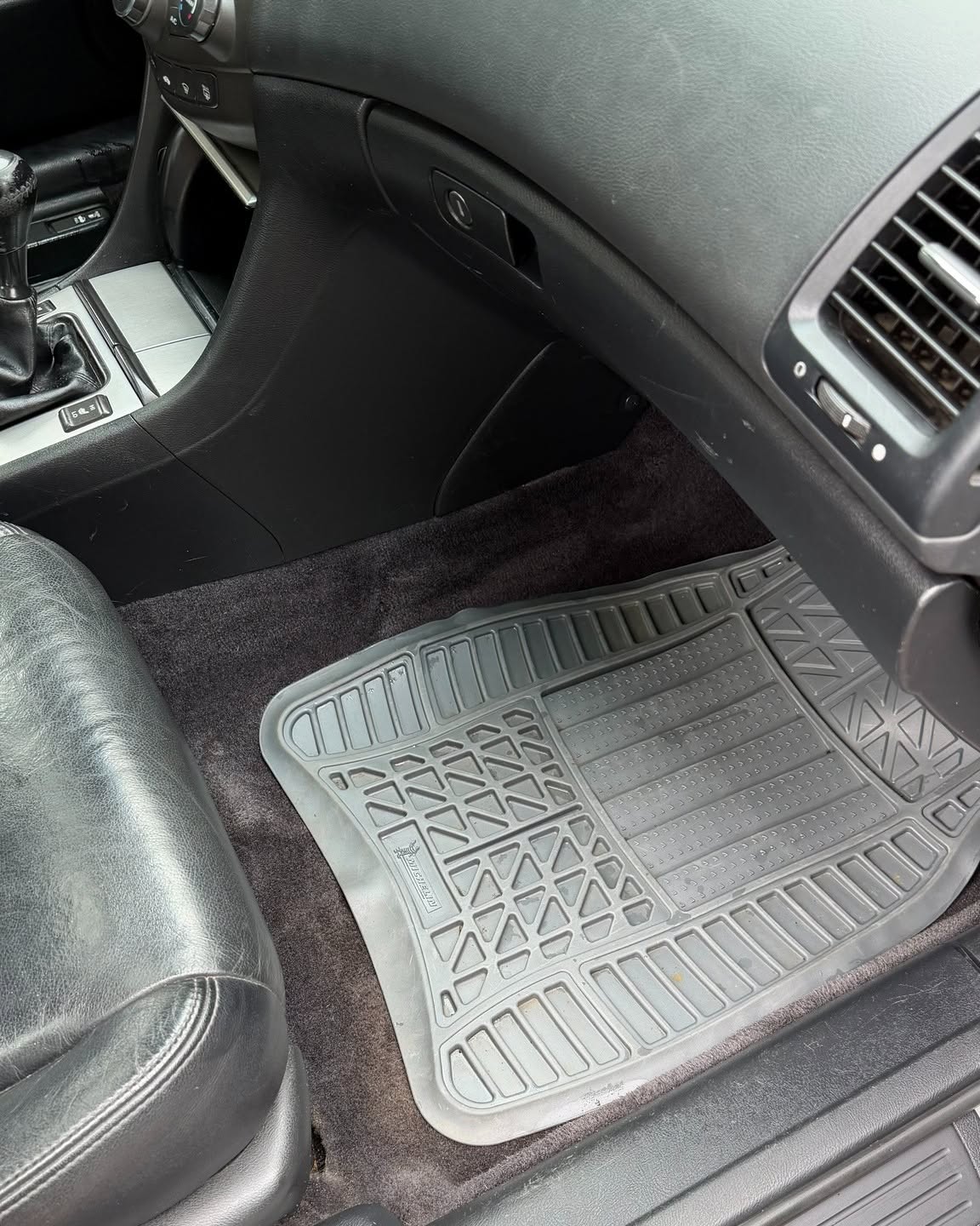 Passenger footwell and floor mat before cleaning